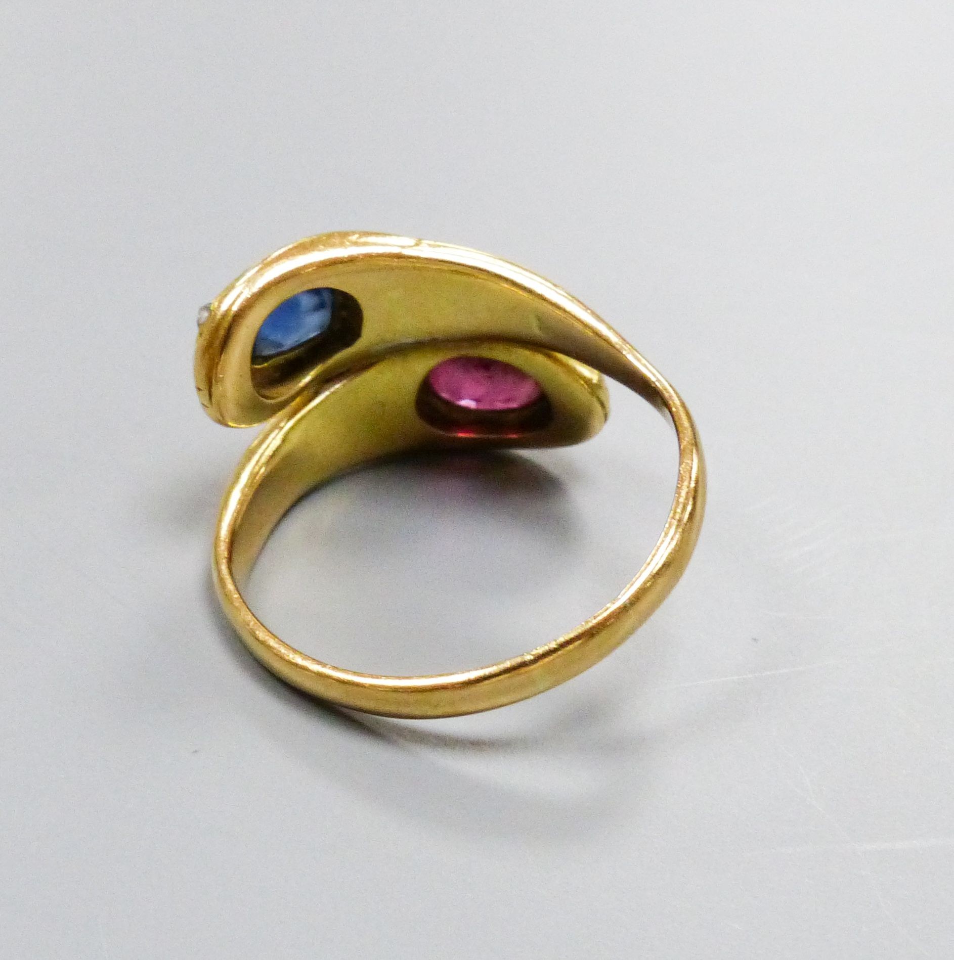 An 18ct yellow gold double 'cobra' ring, sapphire and ruby set, size Q/R, gross 7.6 grams.